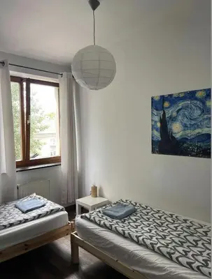 a bedroom with two beds and a pendant light at Piekny,duzy loft 80 metrow blisko centrum in Kraków