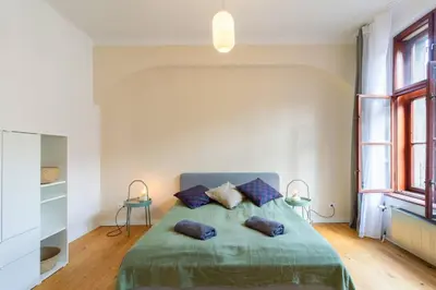 a bedroom with a green bed with two pillows at Vintage Charm-3 Bedrooms-Old Town in Kraków