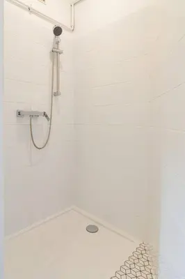 a bathroom with a shower with white tiles at Vintage Charm-3 Bedrooms-Old Town in Kraków