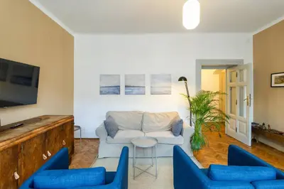 a living room with a white couch and blue chairs at Vintage Charm-3 Bedrooms-Old Town in Kraków