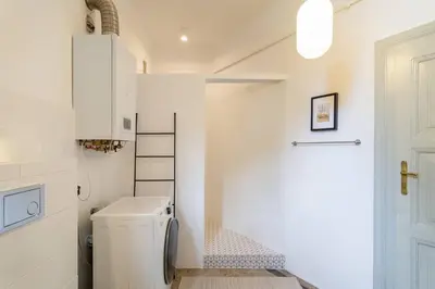 a bathroom with a washer and dryer next to a door at Vintage Charm-3 Bedrooms-Old Town in Kraków