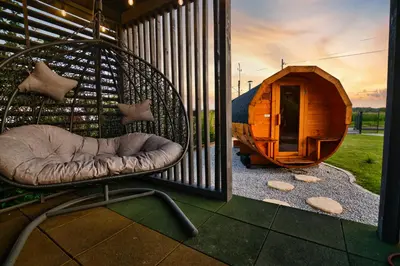 a chair sitting on a porch next to a dog house at Wiklinowa Oaza Zator by Housine in Zator