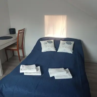 a blue bed with towels on it with a table at U Tofika in Grzechynia