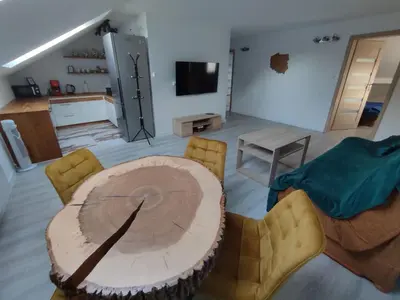 a living room with a wooden table and chairs at U Tofika in Grzechynia