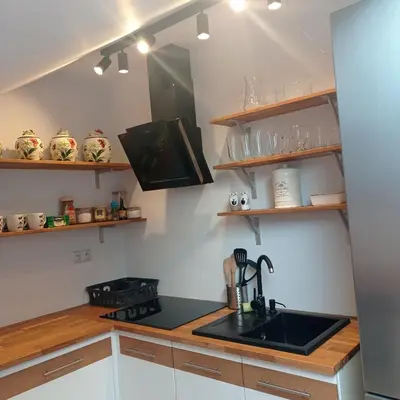 a kitchen with a sink and wooden counters and shelves at U Tofika in Grzechynia