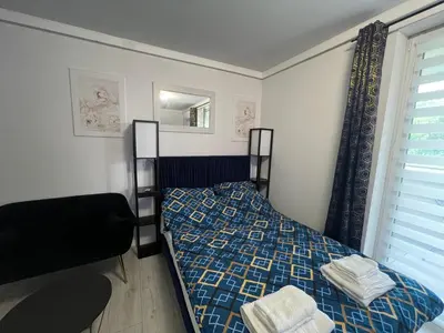 a bedroom with a bed and a mirror and a window at Apartament Bastian Złocień Kraków in Kraków