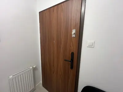 a wooden door in the corner of a room at Apartament Bastian Złocień Kraków in Kraków