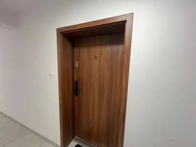 a wooden door in the corner of a room at Apartament Bastian Złocień Kraków in Kraków