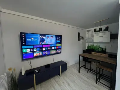a living room with a flat screen tv on a wall at Apartament Bastian Złocień Kraków in Kraków