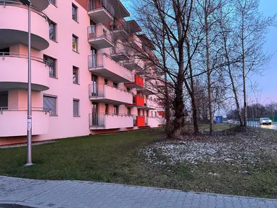 a pink building with a tree in front of it at Apartament Bastian Złocień Kraków in Kraków