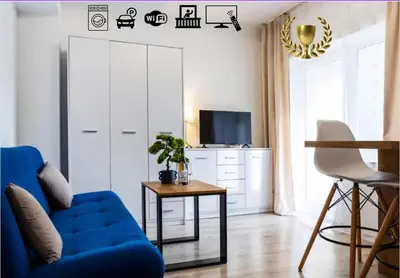 a living room with a blue couch and a table at Aleja 69 Balcony in Kraków