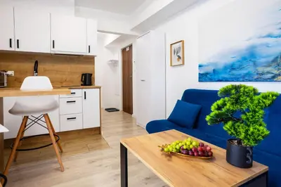 a living room with a blue couch and a table at Aleja 69 Balcony in Kraków
