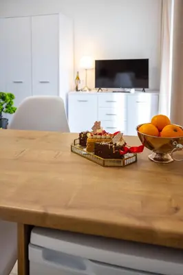 a table with a bowl of oranges and a plate of food at Aleja 69 Balcony in Kraków