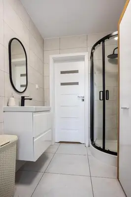 a bathroom with a white door and a mirror at Aleja 69 Balcony in Kraków