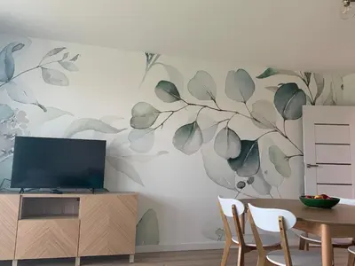 a living room with a tv and a tree mural on the wall at Smile 2 in Tomice