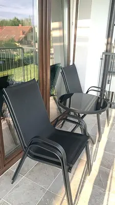 two black chairs and a table on a balcony at Smile 2 in Tomice