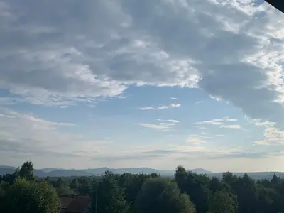 a cloudy sky with trees and mountains in the distance at Smile 2 in Tomice