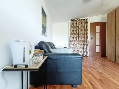 a living room with a blue couch and a table at pokoje przytulnie jak w domu in Kraków