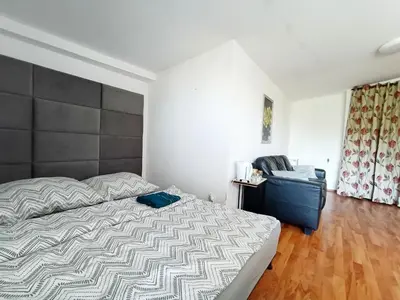 a bedroom with a large bed and a chair at pokoje przytulnie jak w domu in Kraków