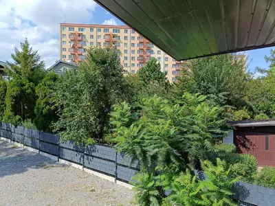 a retaining wall with trees and plants at pokoje przytulnie jak w domu in Kraków