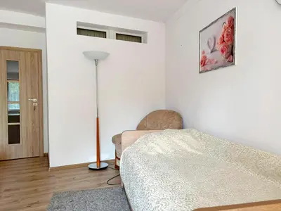 a living room with a bed and a lamp at pokoje przytulnie jak w domu in Kraków