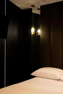a black bedroom with a bed and two lights at Native Apartments Kościuszki 39I11 in Kraków