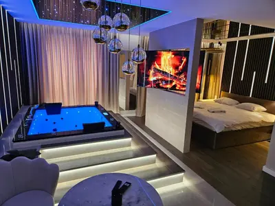 a living room with a hot tub and a fireplace at Masarska 8 VIP Apartamenty JACUZZI in Kraków