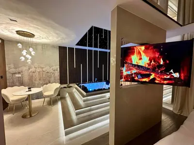 a living room with a tv on a wall at Masarska 8 VIP Apartamenty JACUZZI in Kraków