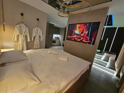 a bedroom with a large bed and a tv on a wall at Masarska 8 VIP Apartamenty JACUZZI in Kraków