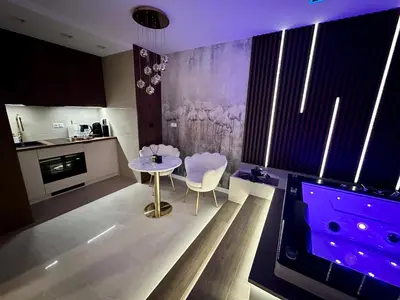 a living room with a tv and a table and chairs at Masarska 8 VIP Apartamenty JACUZZI in Kraków