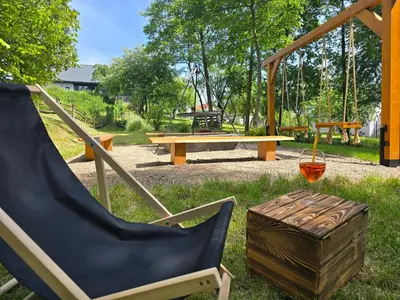 a swing yard with a chair and a picnic table at Stodoła Na Kamionce in Kwaczała