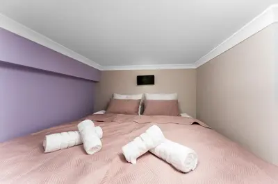 a bedroom with a large bed with towels on it at Tomasza Apartments by VSI in Kraków