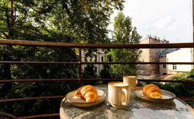 two plates of croissants on a table on a balcony at Tomasza Apartments by VSI in Kraków