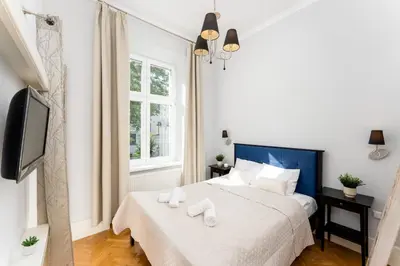a bedroom with a bed with two towels on it at Tomasza Apartments by VSI in Kraków
