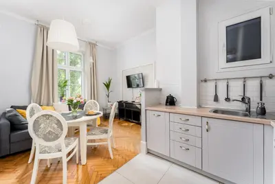 a kitchen and living room with a table and chairs at Tomasza Apartments by VSI in Kraków