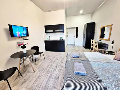a room with a bed and a table and a kitchen at DReAM Main Station in Kraków