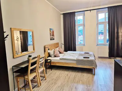 a bedroom with a bed and a table and a mirror at DReAM Main Station in Kraków