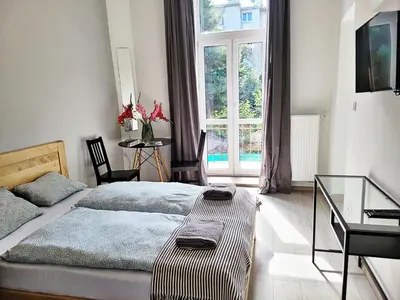 a bedroom with two beds and a large window at DReAM Main Station in Kraków