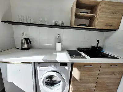 a kitchen with a washing machine and a sink at DReAM Main Station in Kraków