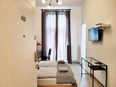a bedroom with a bed and a desk and a window at DReAM Main Station in Kraków
