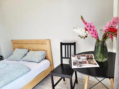 a bedroom with a bed and a table with a vase of flowers at DReAM Main Station in Kraków
