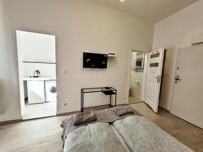 a bedroom with a bed and a television on the wall at DReAM Main Station in Kraków