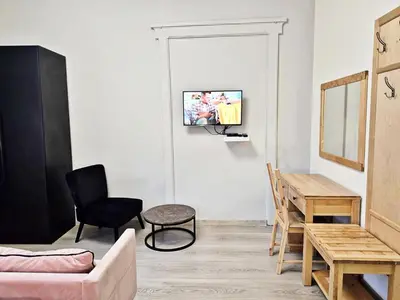 a living room with a couch and a table and a tv at DReAM Main Station in Kraków