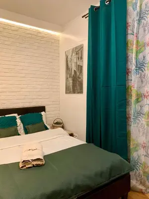 a bedroom with a bed with a blue shower curtain at Green Apartment Krakow in Kraków