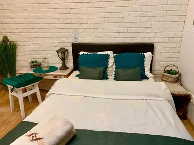a bedroom with a large bed with blue pillows at Green Apartment Krakow in Kraków