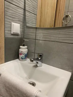 a white sink in a bathroom with a mirror at Green Apartment Krakow in Kraków