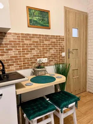 a kitchen with a table with two green seats at Green Apartment Krakow in Kraków