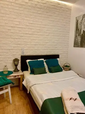 a bedroom with a bed with blue and green pillows at Green Apartment Krakow in Kraków