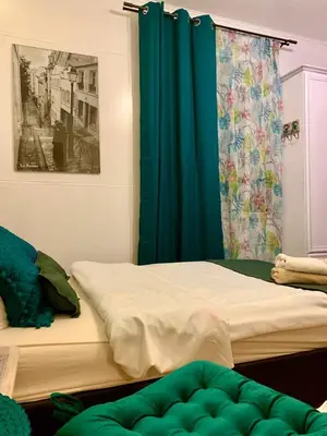 two beds in a room with a green curtain at Green Apartment Krakow in Kraków