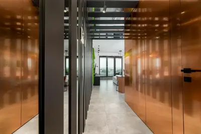 a hallway with wooden doors in a office building at Wiślane Tarasy - UNIQUE Apartments 4YOU - 9 piętro z pięknym widokiem na centrum Krakowa in Kraków